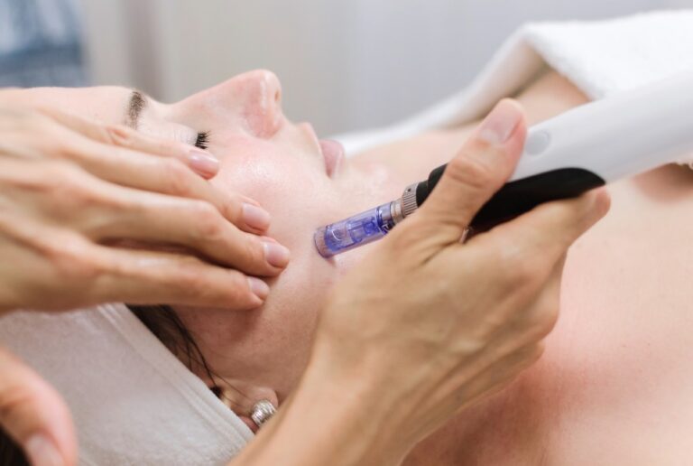 Facial treatment with a handheld skincare device in a clinic setting.